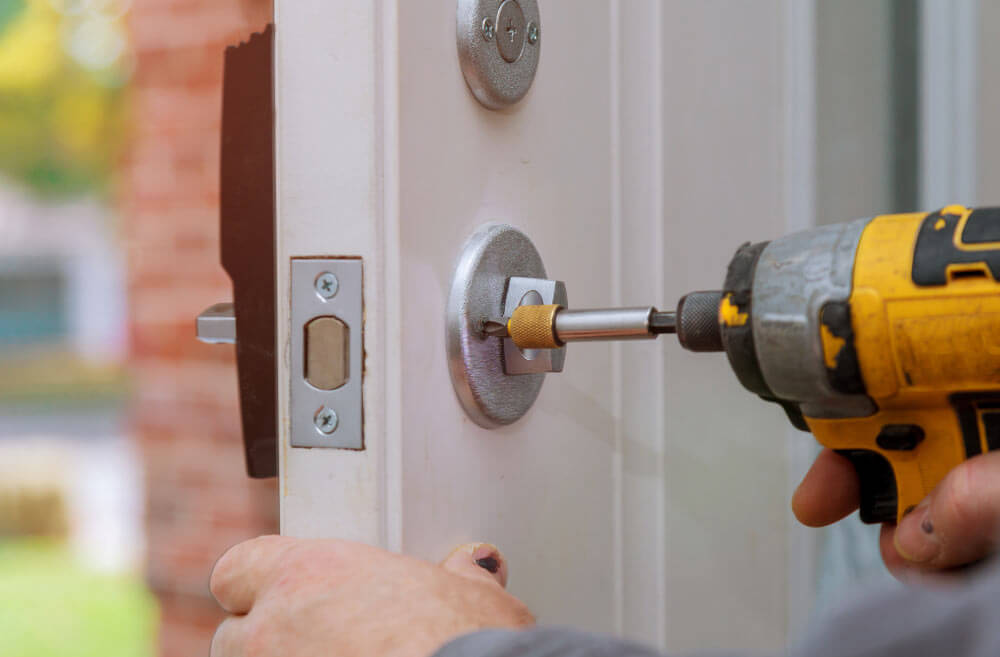 Handyman Doing Door Repairs And Installing New Door Locker